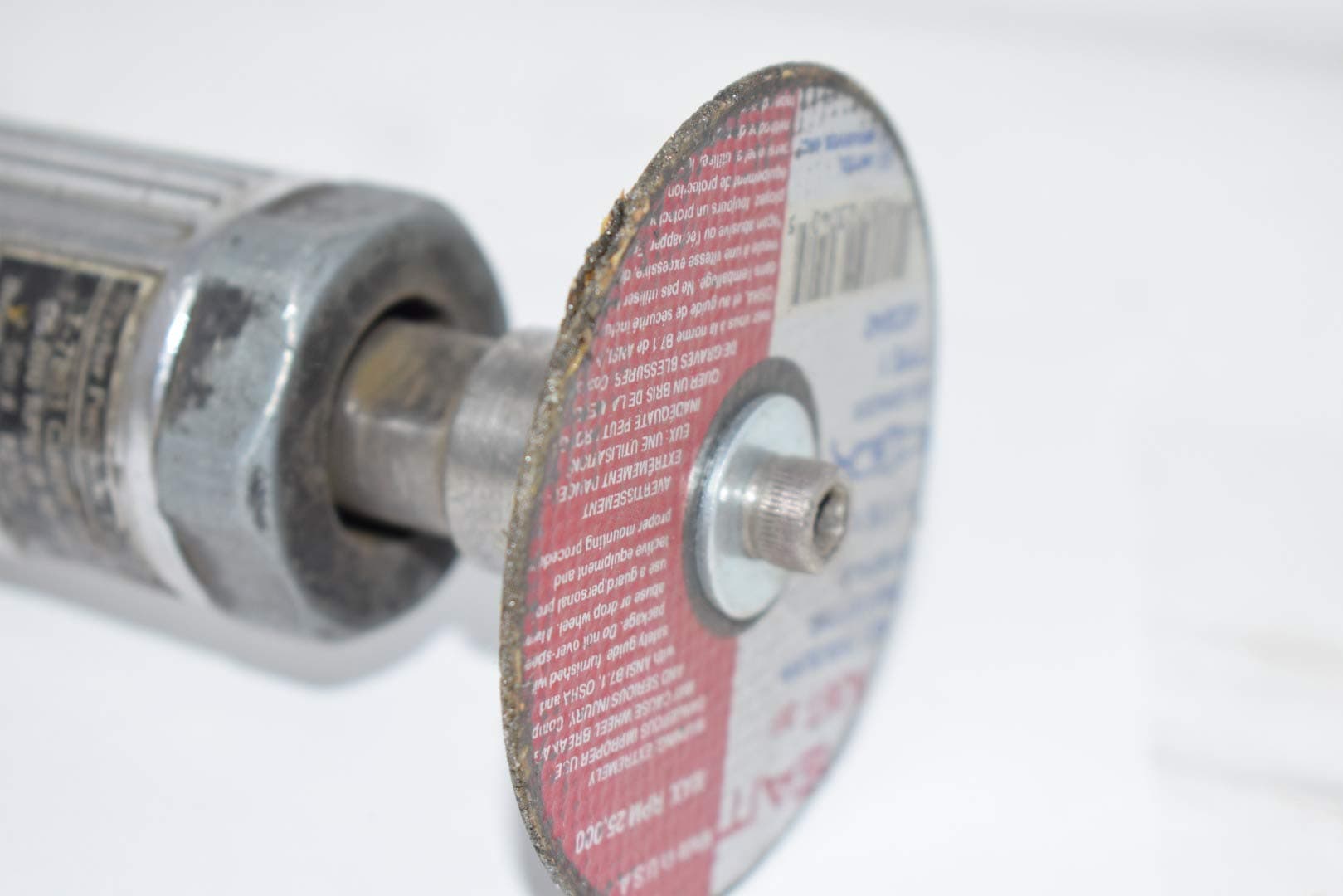 Close-up of a 3-inch cutoff tool with a red and blue abrasive cutting disc on a white background.