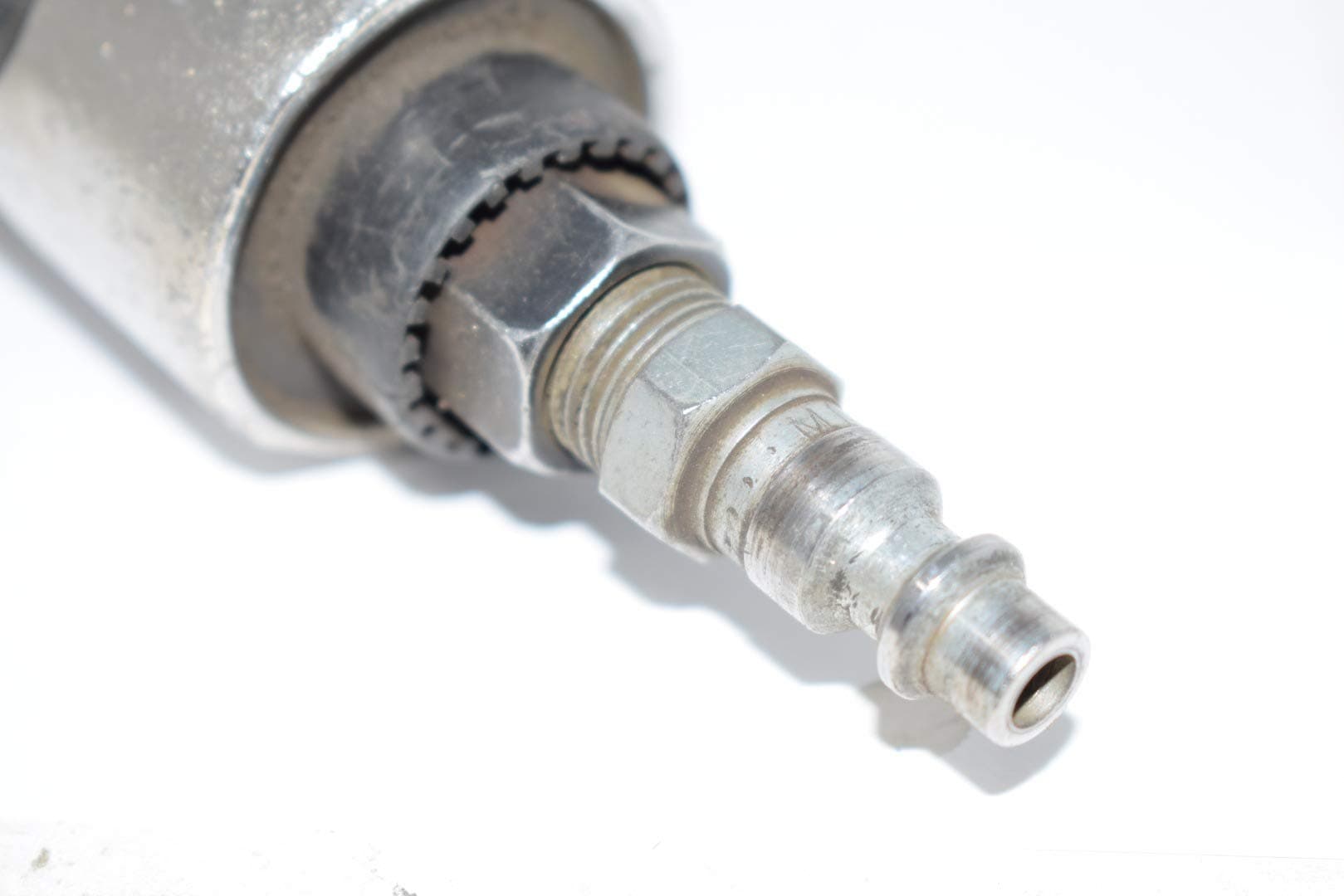 Close-up of a metal air inlet fitting with threaded hex nut on a 3-inch cutoff tool.