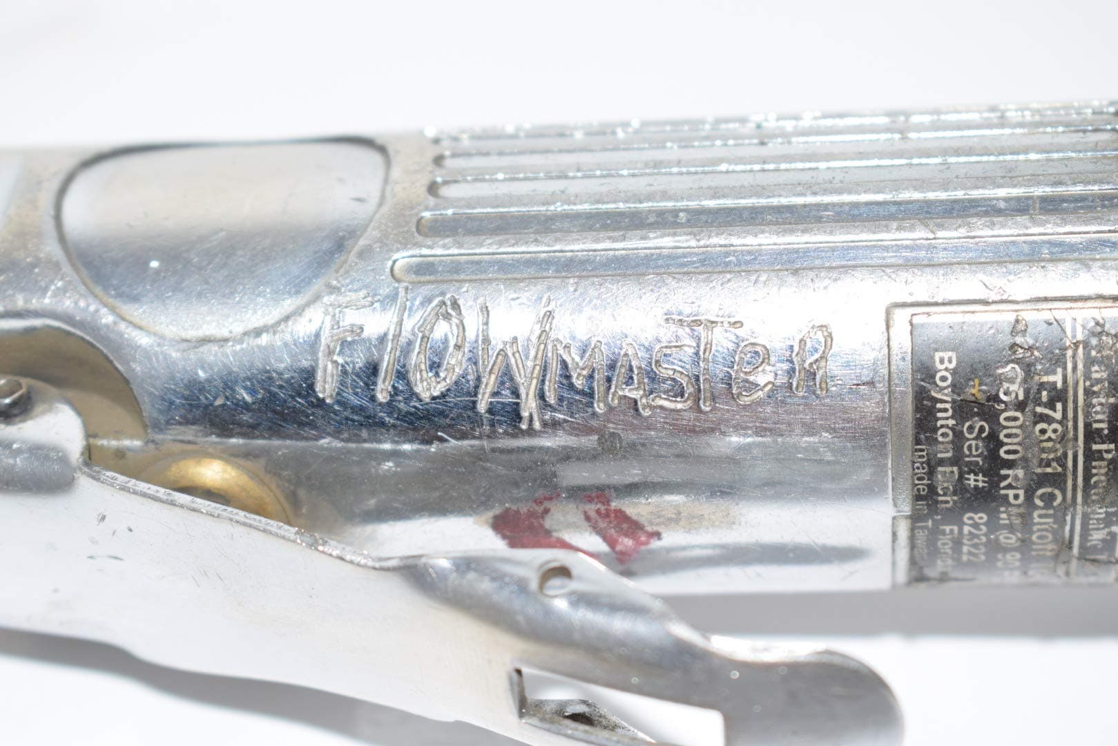 Close-up of a silver Flowmaster 3-inch cutoff tool with engraved brand name and technical label.